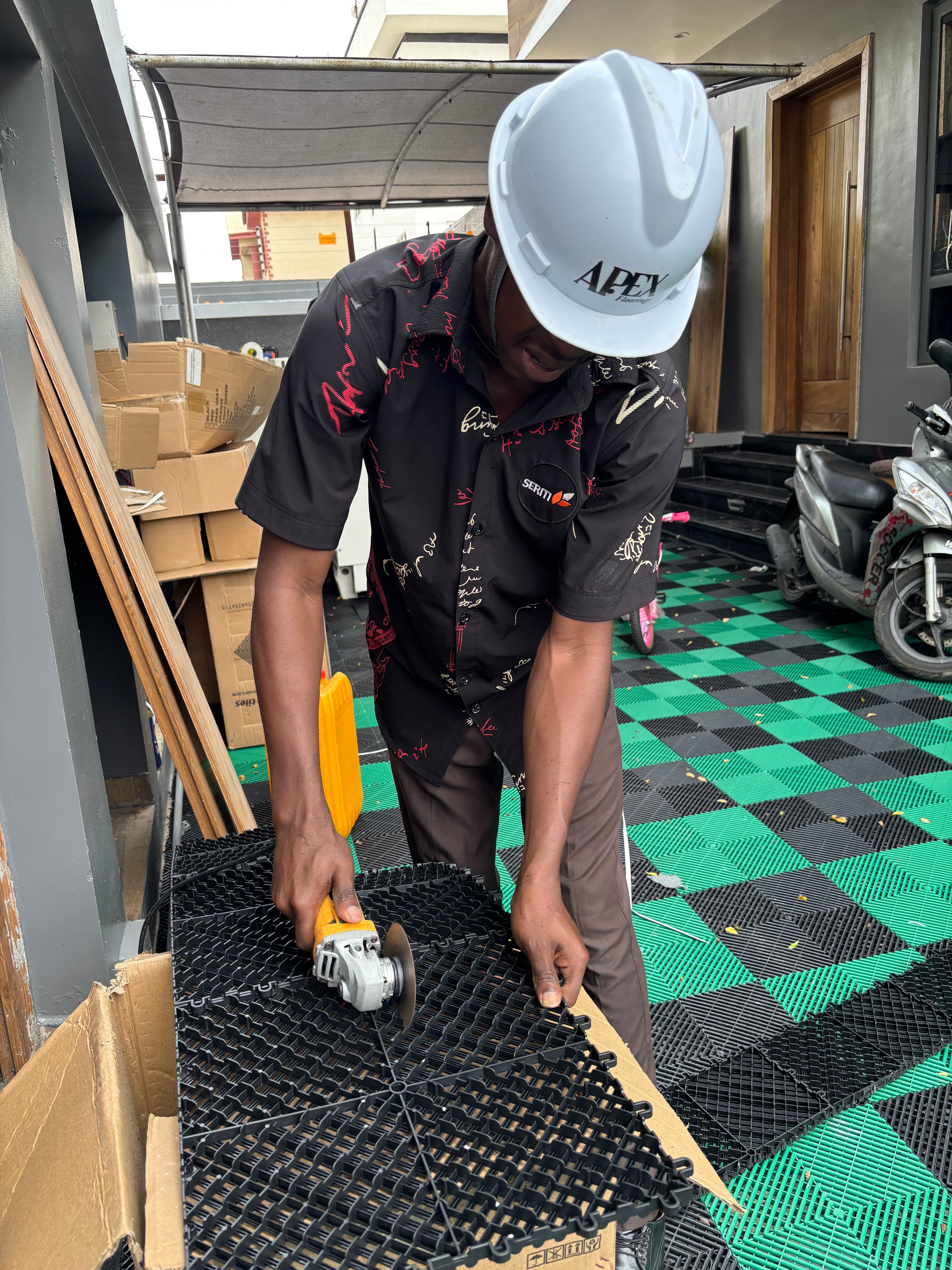 Apex installer cutting tiles on-site — JETOUR project