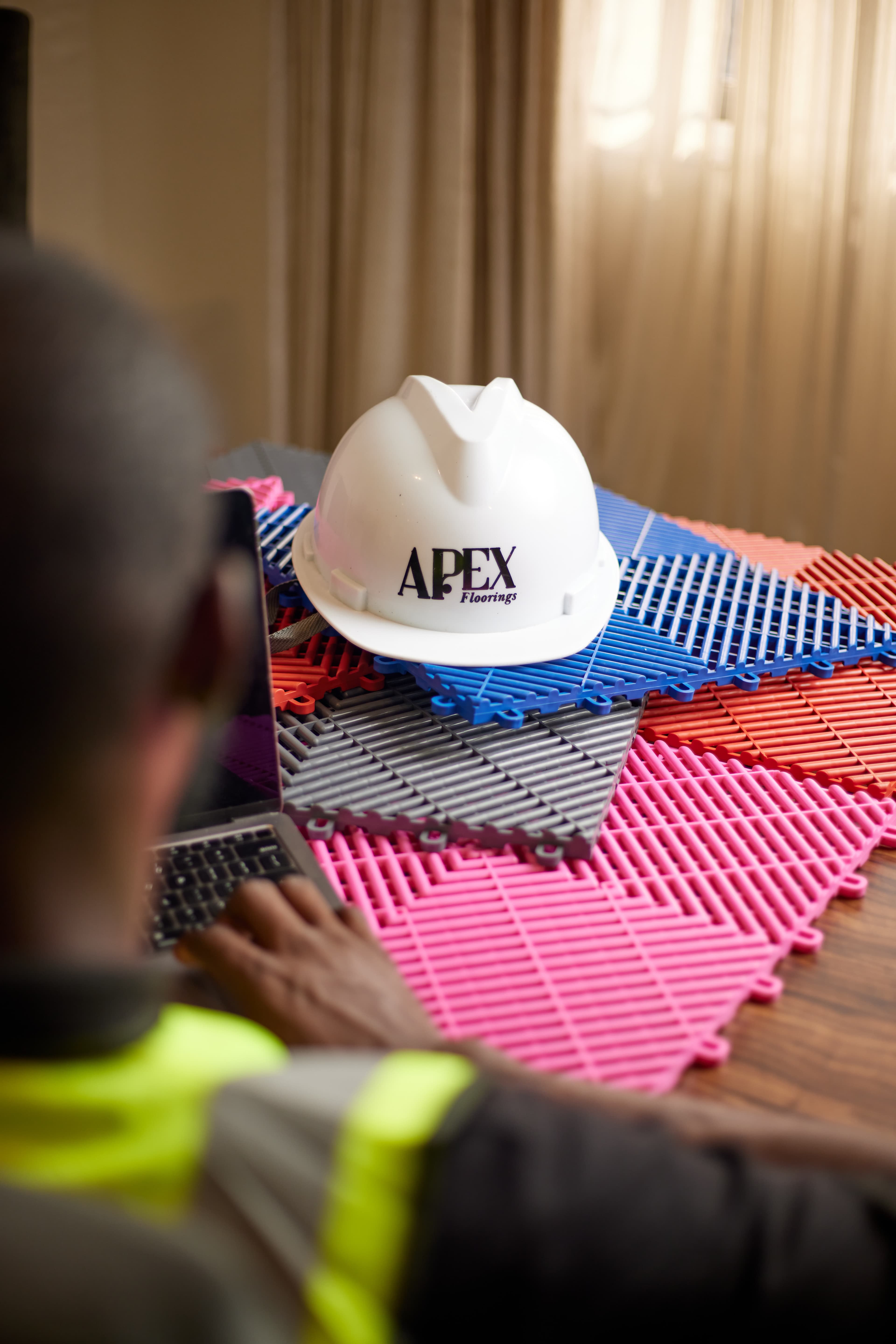 Apex Floorings — branded hard hat on colour tile range