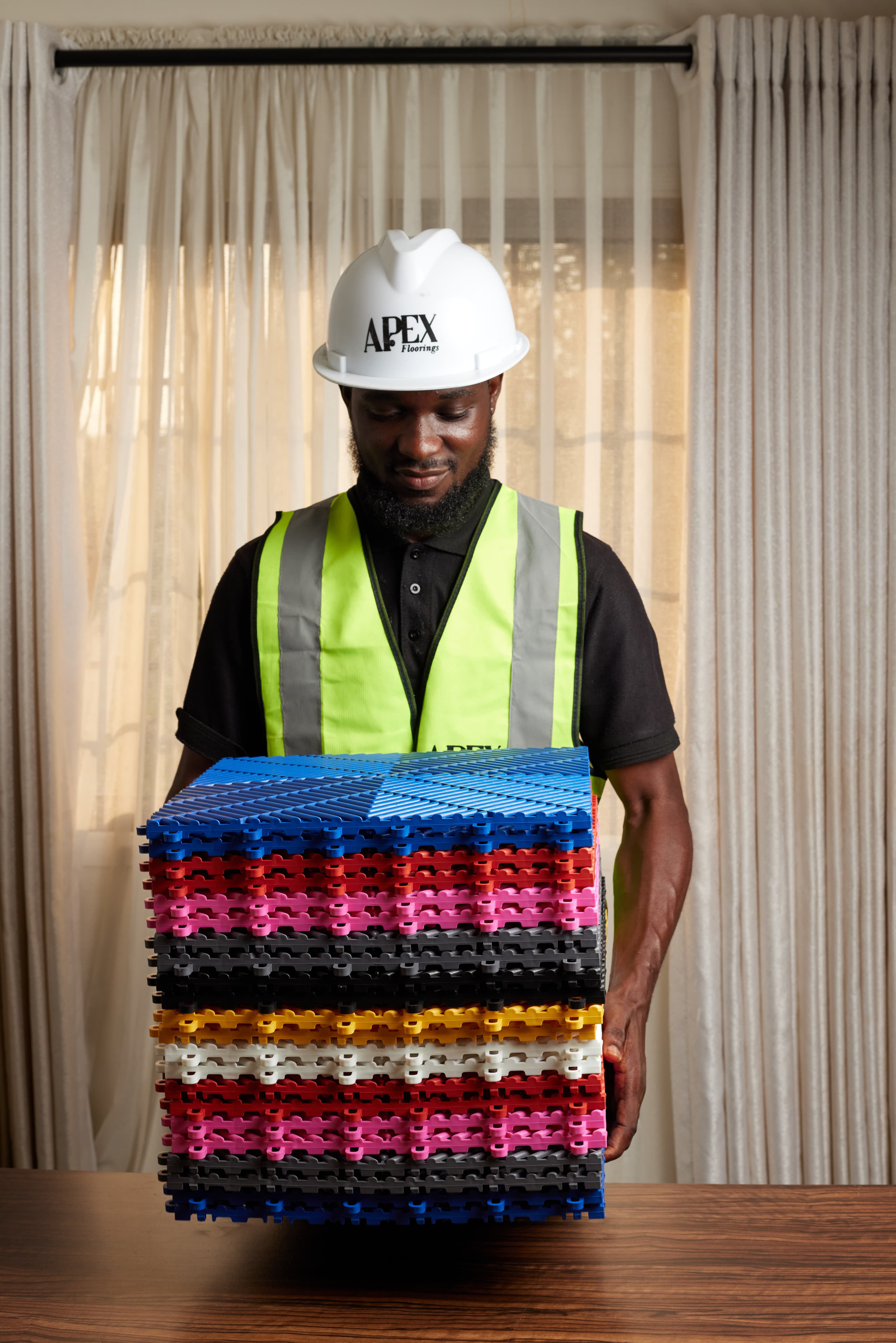 Apex team member holding stack of multi-colour tiles