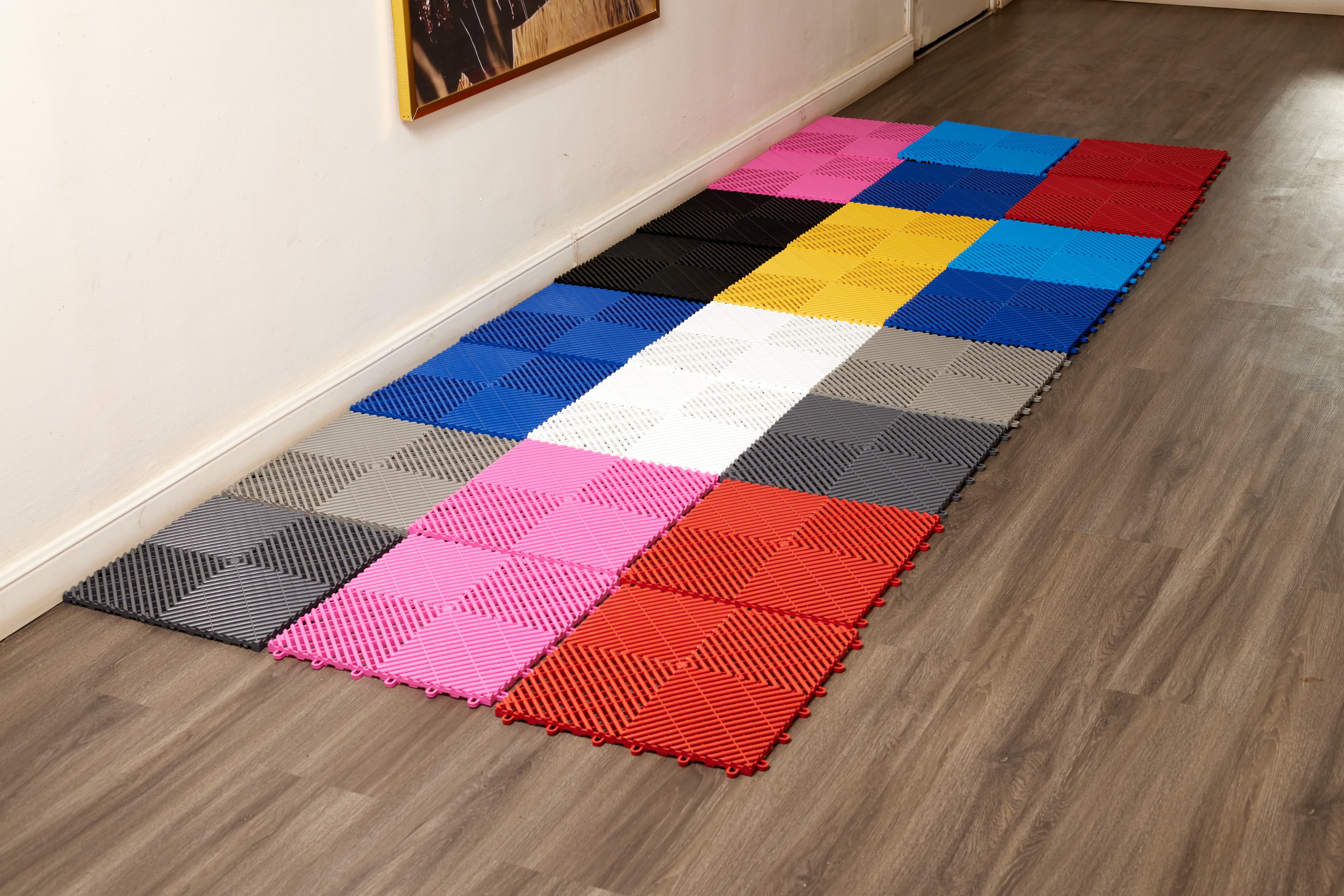 Multi-colour interlocking tile mat on wood flooring