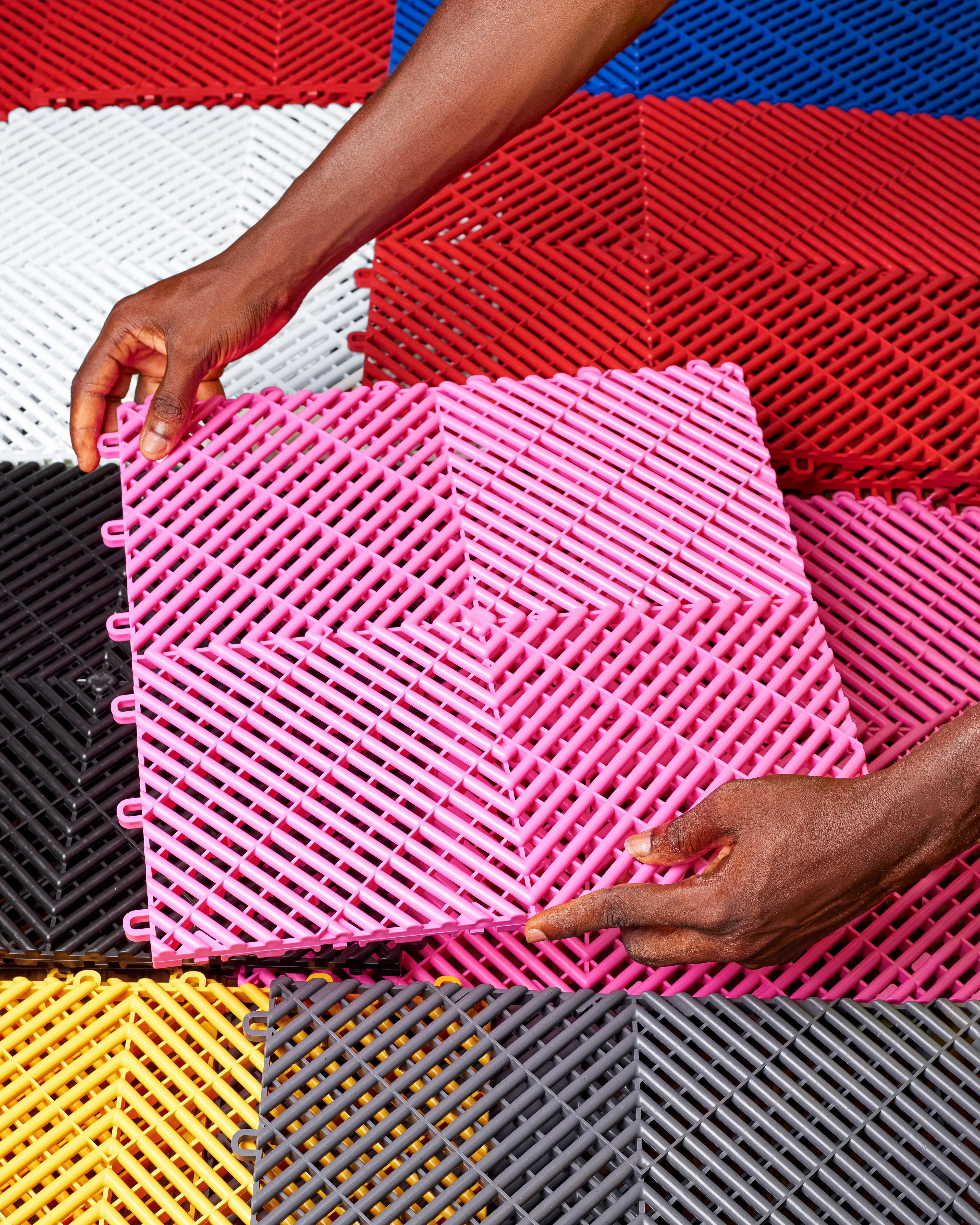 Installer placing fuchsia interlocking tile