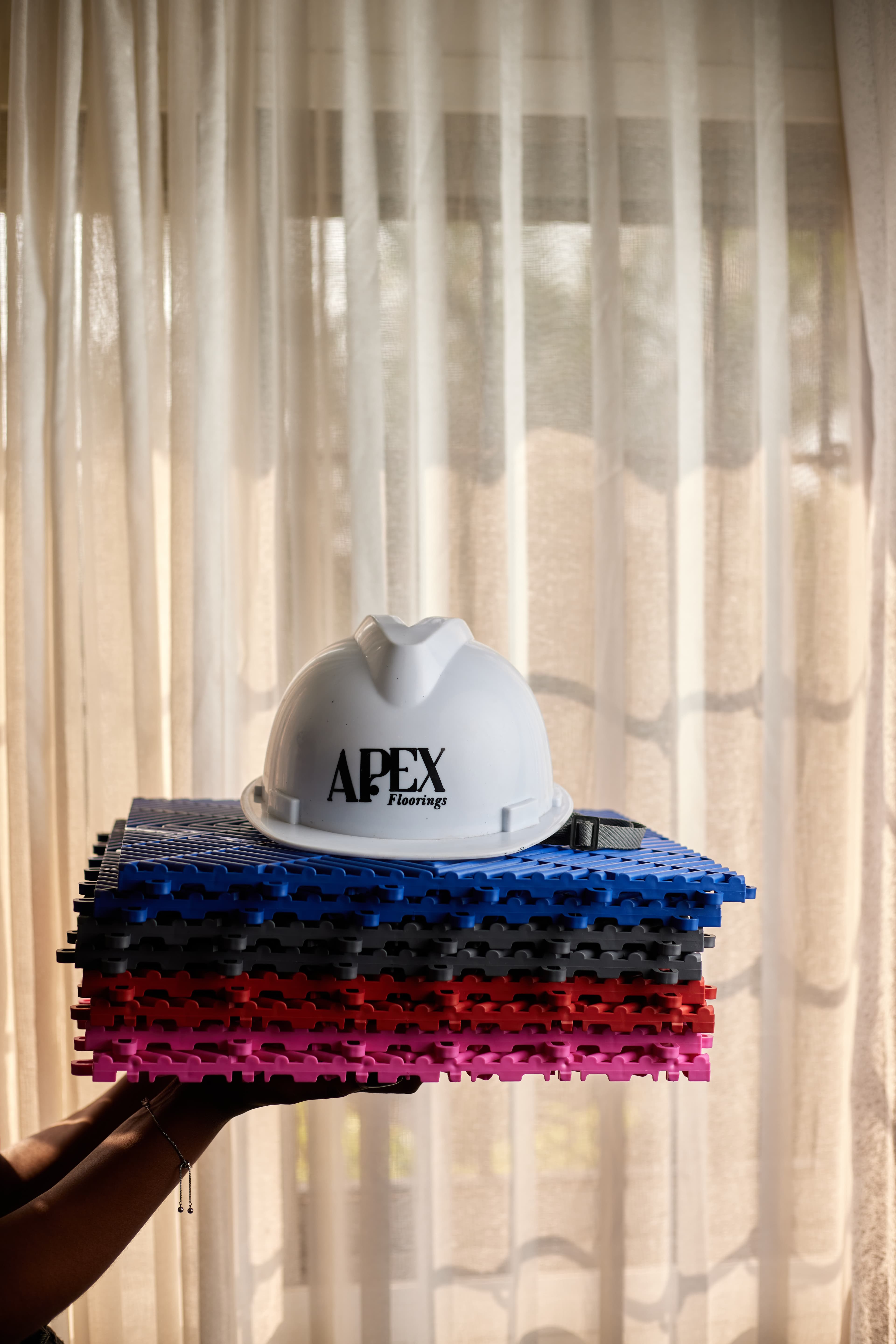 Apex Floorings hard hat balanced on tile stack